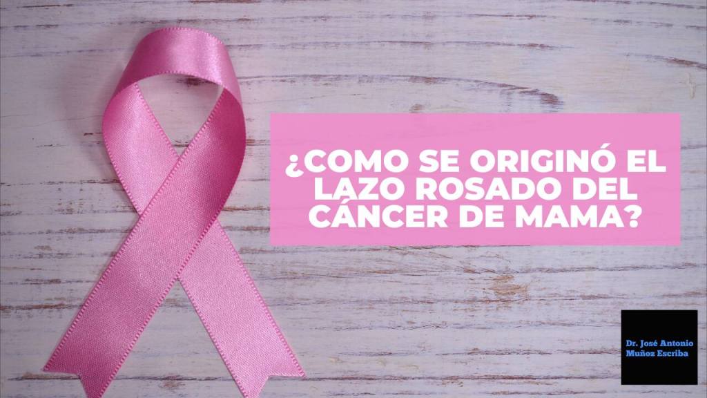 Un lazo rosado símbolo de la lucha contra el cáncer de mama, sobre uns tabla de madera, con un escrito en el que se lee "¿como se originó el lazo rosado del cáncer de mama?"
